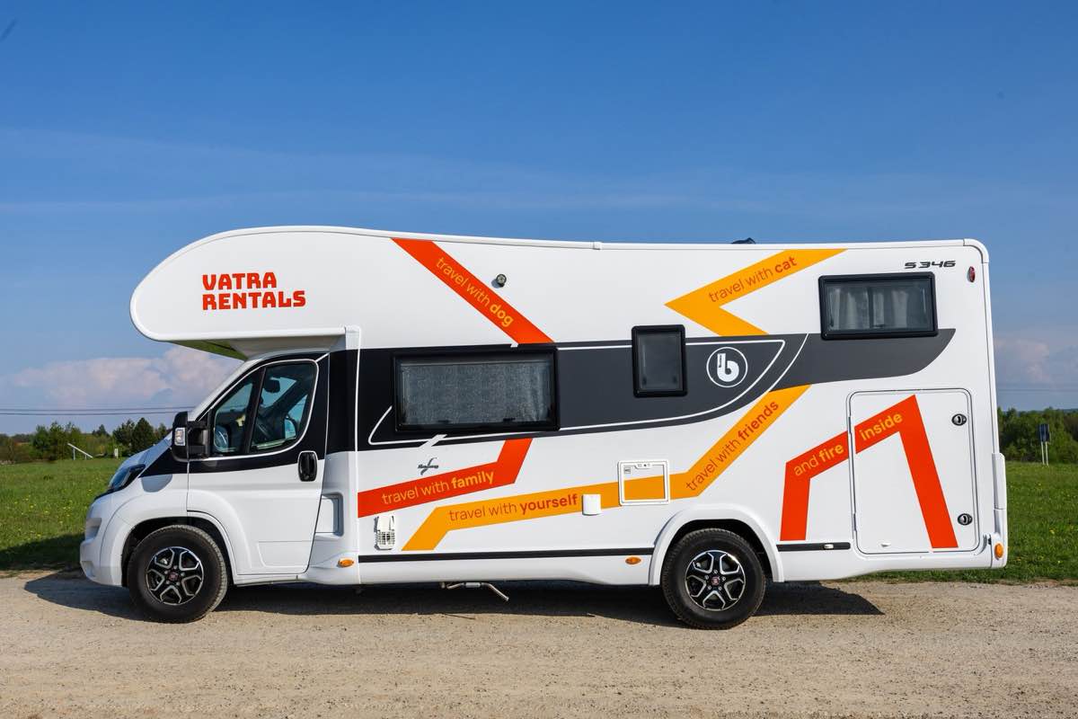 VATRA Rentals Benimar Sport 346 motorhome parked on a gravel lot under a blue sky