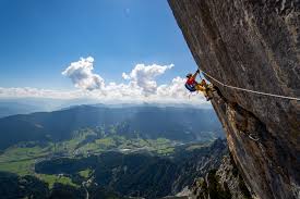 Via ferrata climber on a ridge with lanyards and helmet