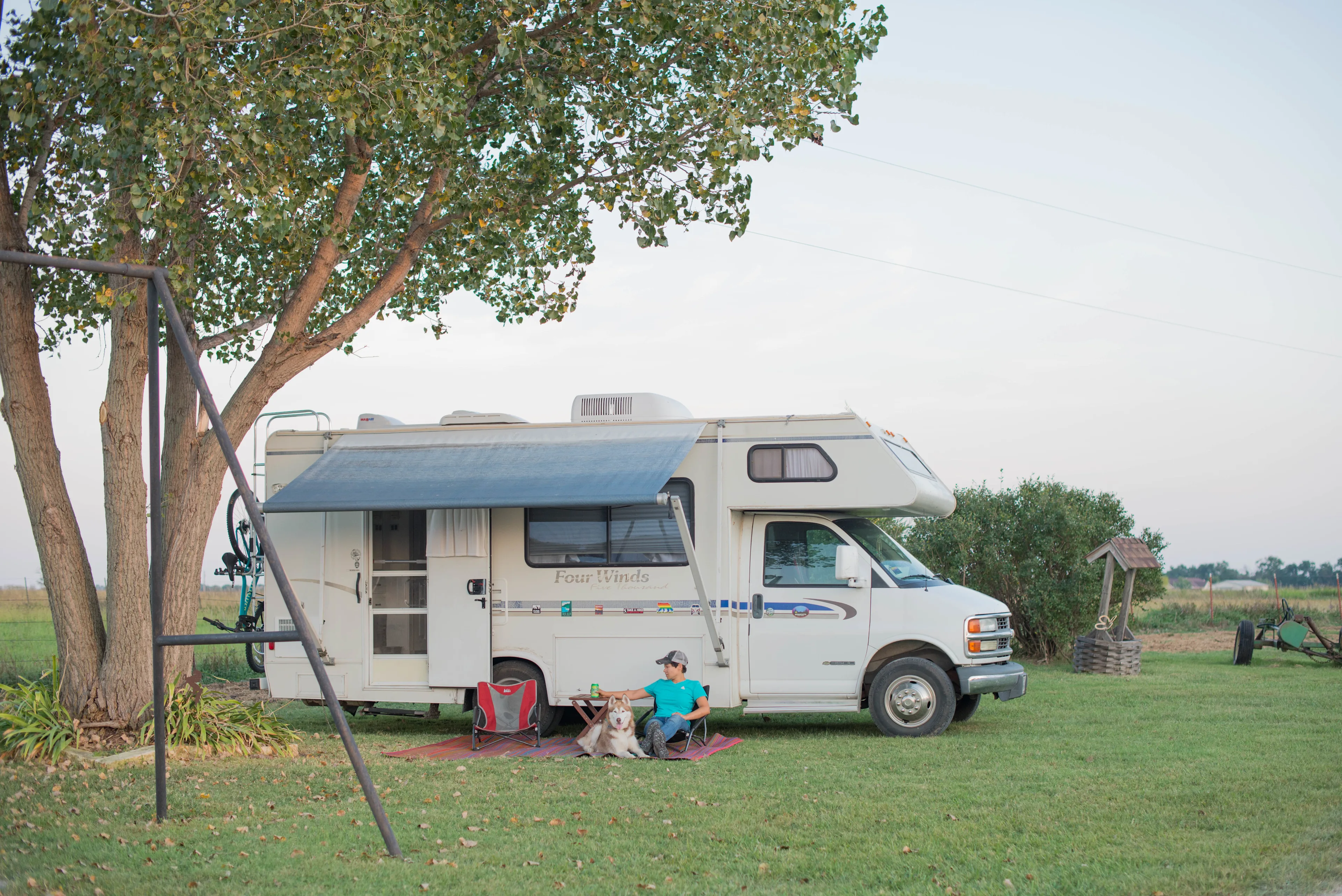 Camper parked at a rustic farm stay with apple trees